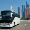 Premium Coach Bus UAE – SSM Chauffeurs Luxury coach bus parked against UAE city skyline