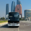 Luxury Coach Bus Service – SSM Chauffeurs Black luxury coach bus with UAE city skyline in background