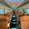 Premium Luxury Bus Seating – SSM Chauffeurs Spacious luxury bus interior with rows of tan passenger seats