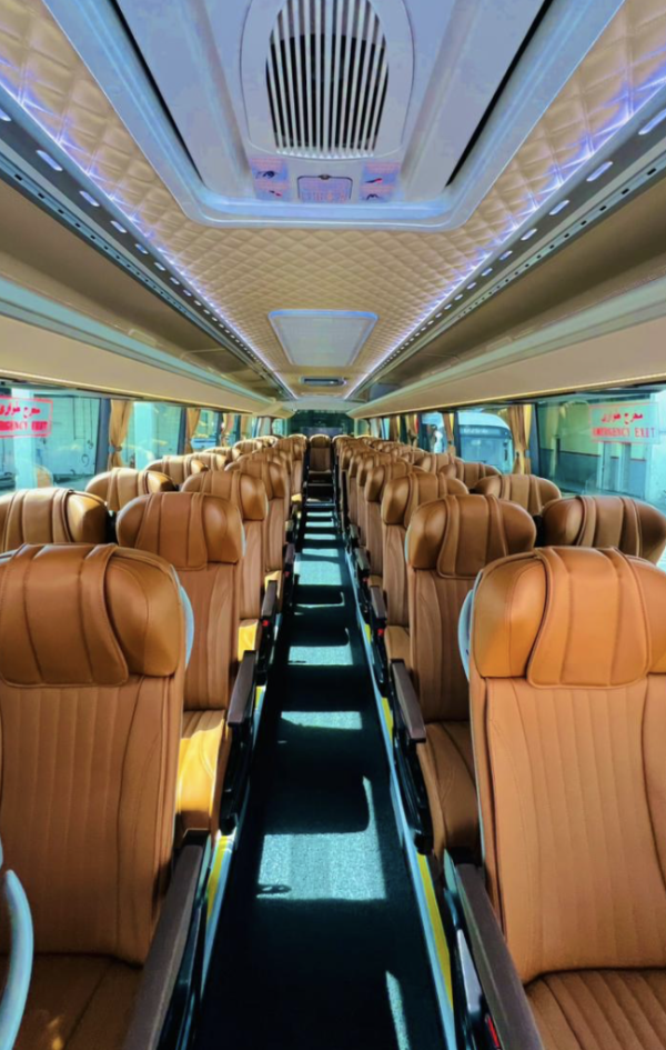Premium Luxury Bus Seating – SSM Chauffeurs Spacious luxury bus interior with rows of tan passenger seats