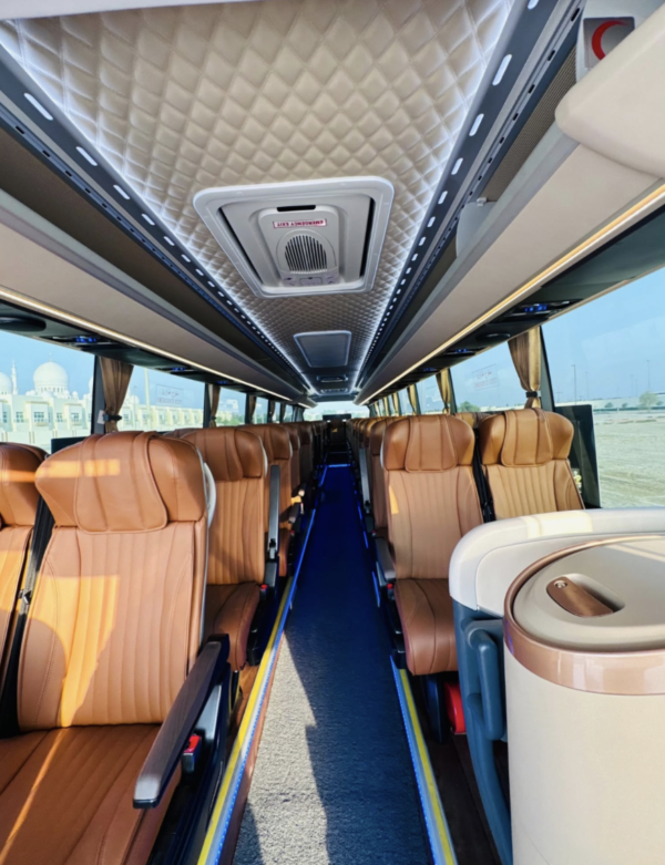 Luxury Coach Bus Interior – SSM Chauffeurs Luxury coach bus interior with tan leather seats and overhead lighting